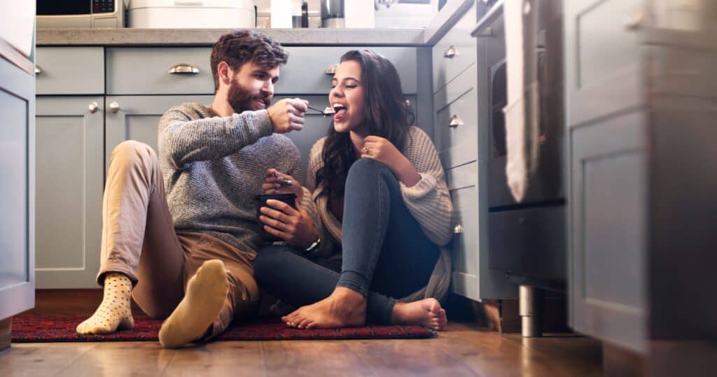couple leisure time married couple sitting on the kitchen floor eating