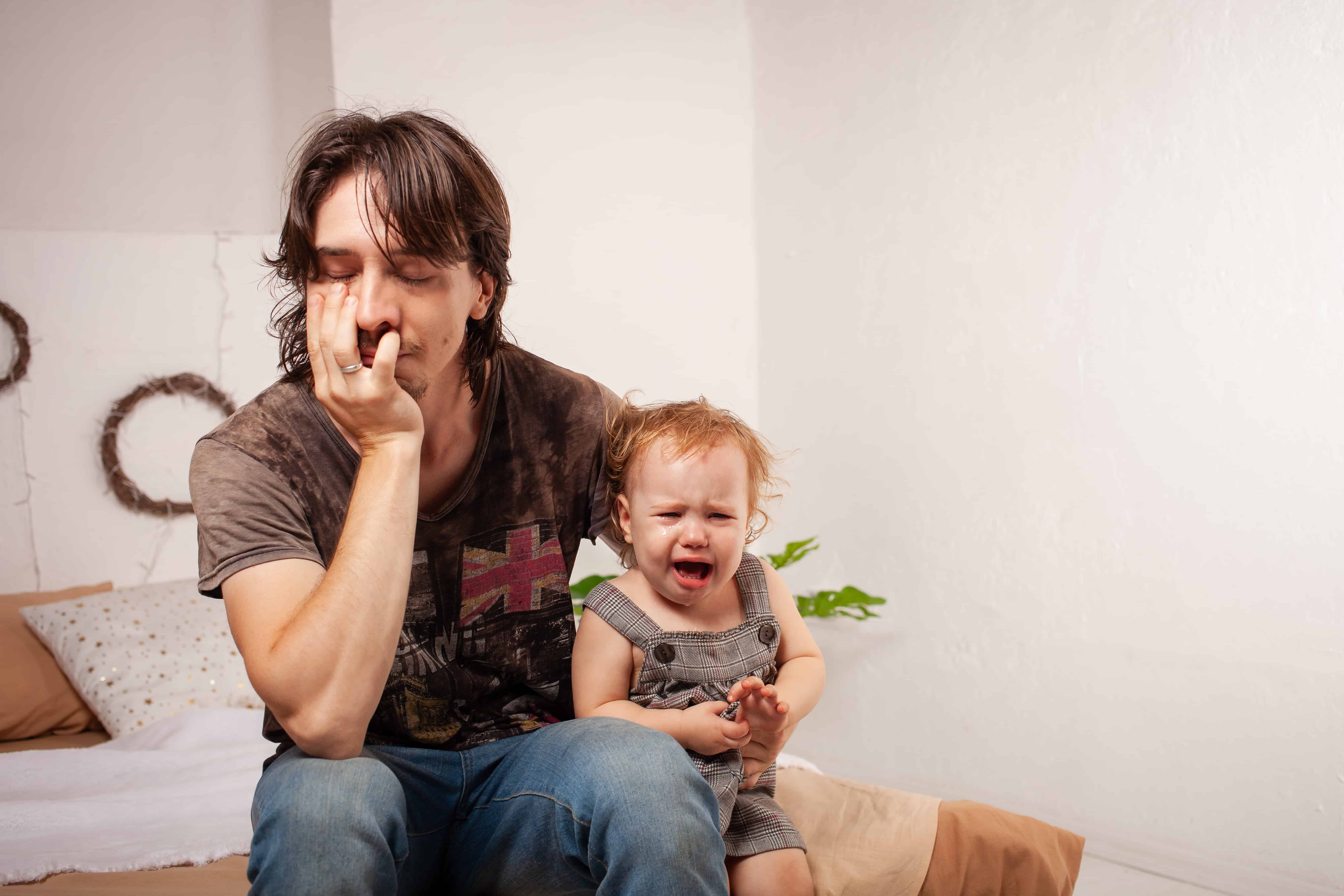signs of parental burnout, stress vs parental burnout, stressed dad with a crying baby