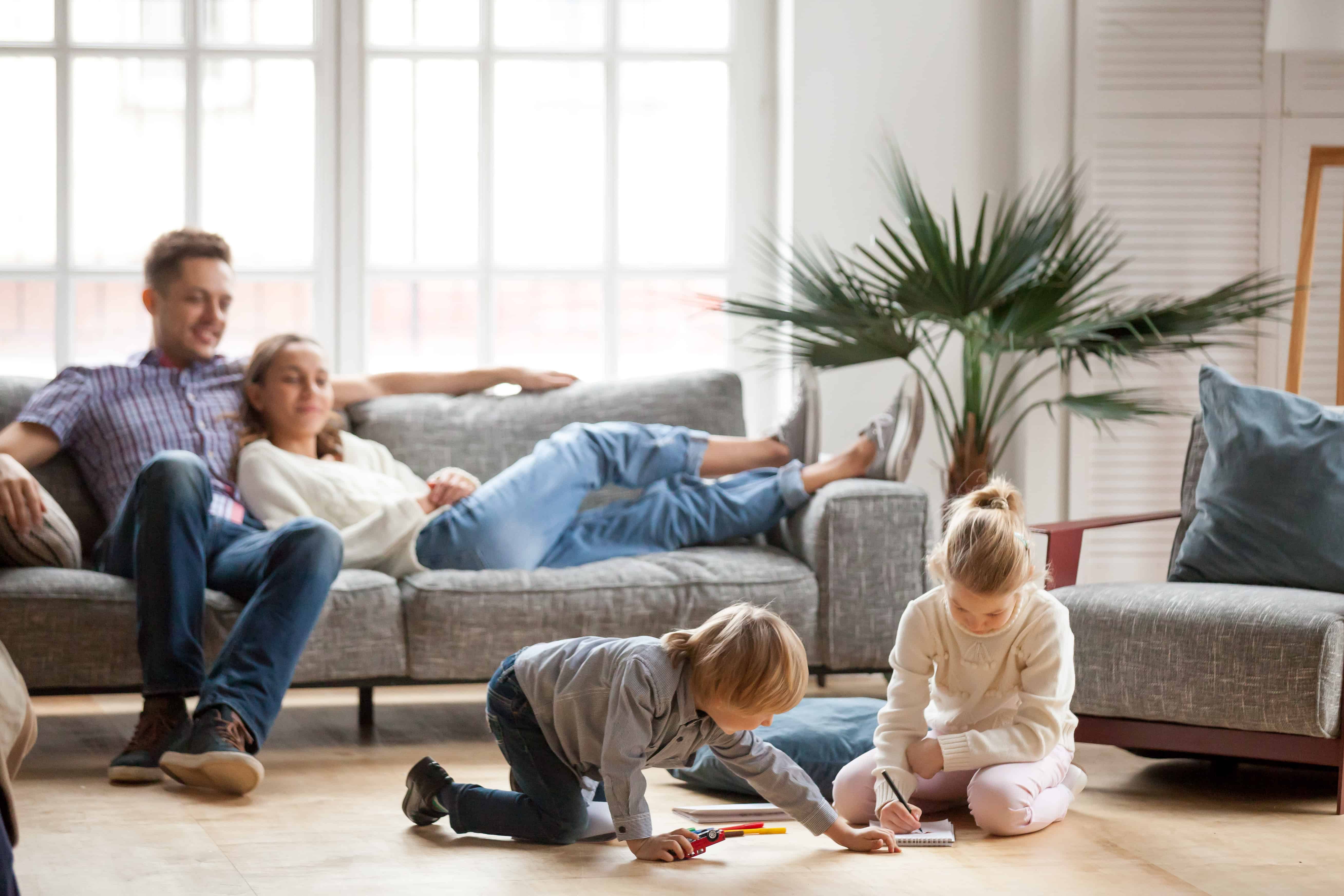 signs of parental burnout, setting boundaries, parents watch their kids playing in the living room