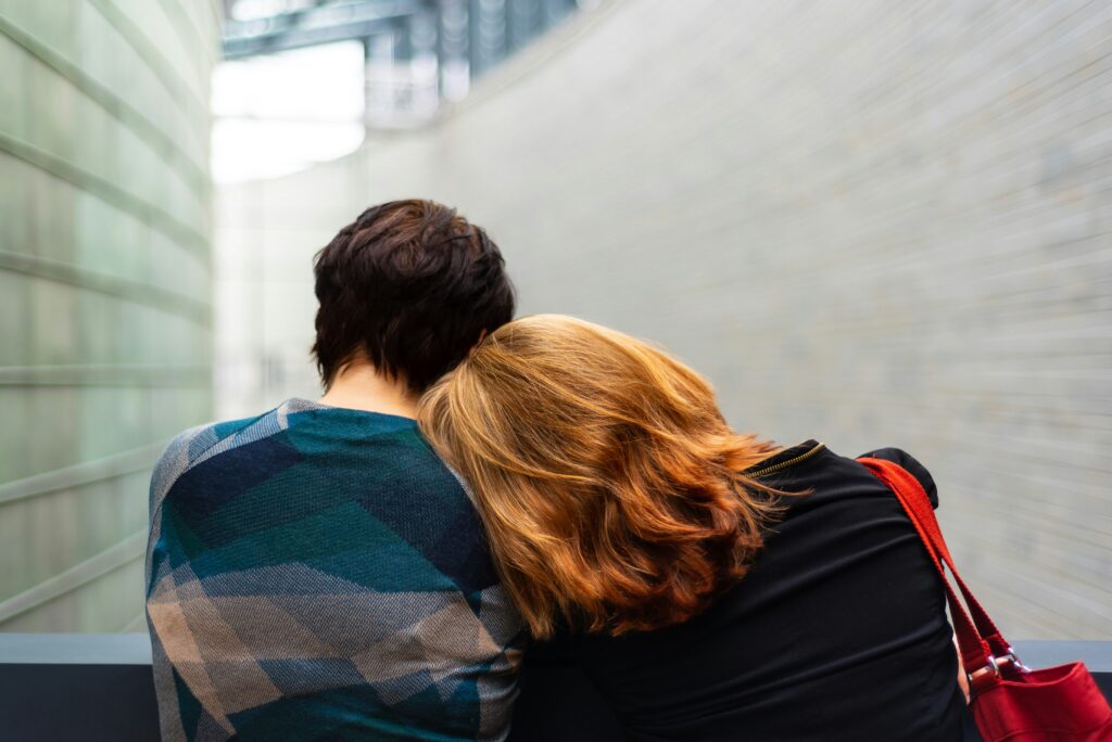 A couple sitting on a bench.