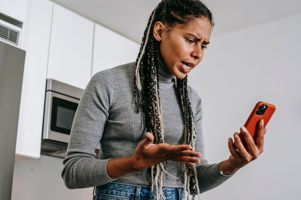 Woman checking her phone late at night, waiting for a reply: breadcrumbing in a relationship